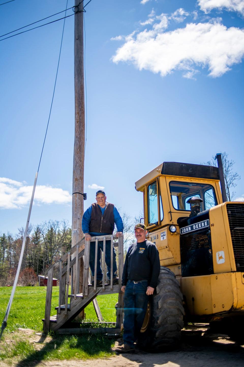 Buddy, left, and son Brent Woodsome stand April 26, 2021, next to the utility pole where a giant headless statue once was in North Waterboro, Maine. "I wish I could have fixed it, but I didn't know how," Buddy said in reference to the statue.