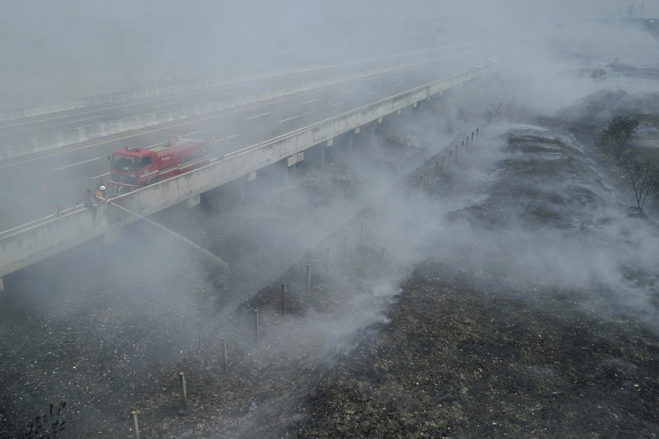 Firefighters attempt to extinguish fire that razes through a landfill in Bekasi, on the outskirts of Jakarta, Indonesia, on Sept. 25, 2023. Pollution is causing respiratory illnesses and deaths to rise in Indonesia's island of Java, including the capital, Jakarta. Data gathered by IQAir, a Swiss air technology company, regularly ranks Jakarta as one of the most polluted cities in the world. Blue skies are a rare sight and the air often smells like fuel or heavy smoke. (AP Photo/Achmad Ibrahim)