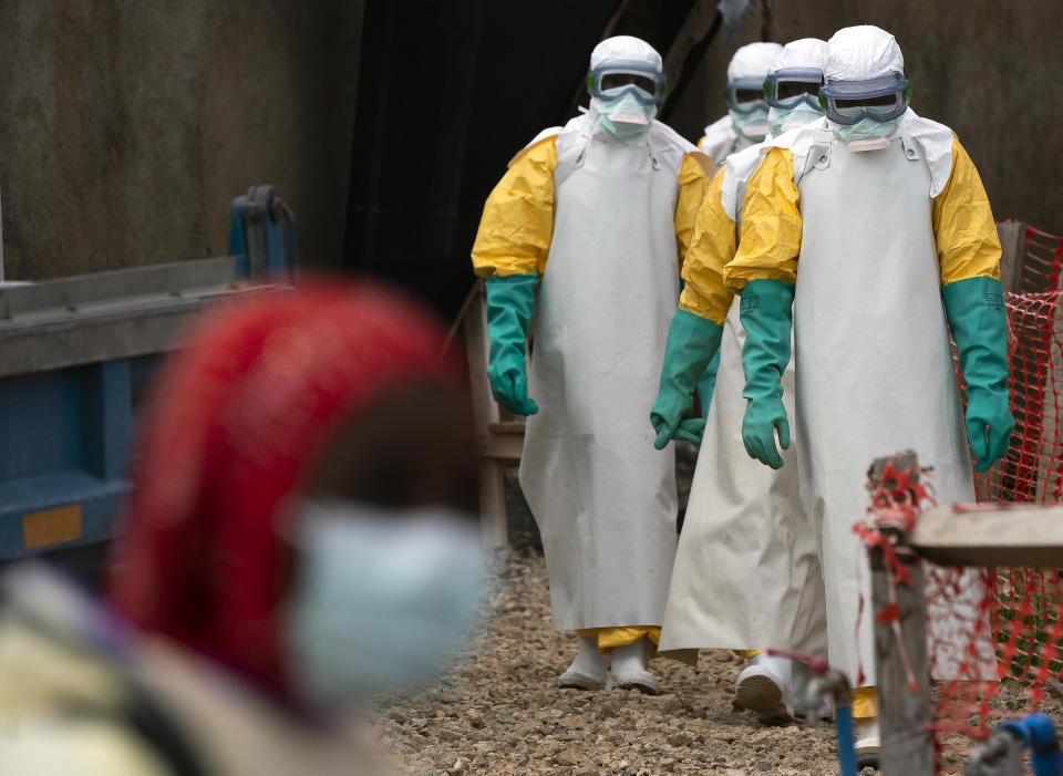 In this Tuesday, July 16, 2019 photo, health workers dressed in protective gear begin their shift at an Ebola treatment center in Beni, Congo DRC. The World Health Organization has declared the Ebola outbreak an international emergency after spreading to eastern Congo's biggest city, Goma, this week. More than 1,600 people in eastern Congo have died as the virus has spread in areas too dangerous for health teams to access. (AP Photo/Jerome Delay)