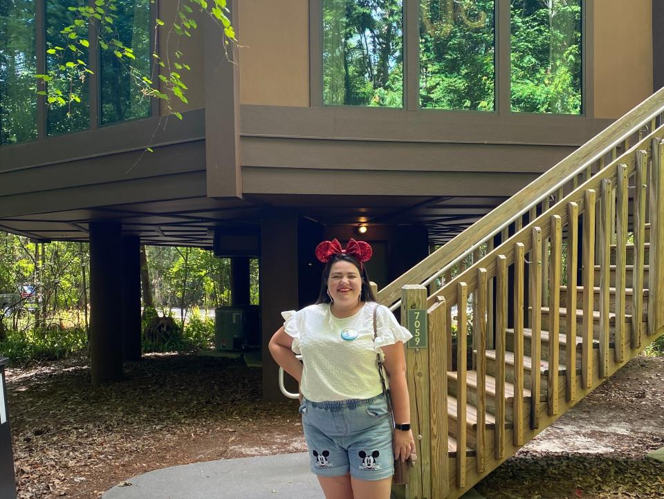 megan posing in front of treehouse villa at saratoga springs