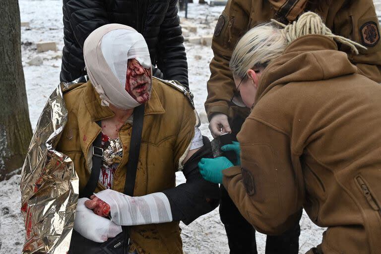 Los médicos atienden a un herido en Kharkiv (Photo by SERGEY BOBOK / AFP)