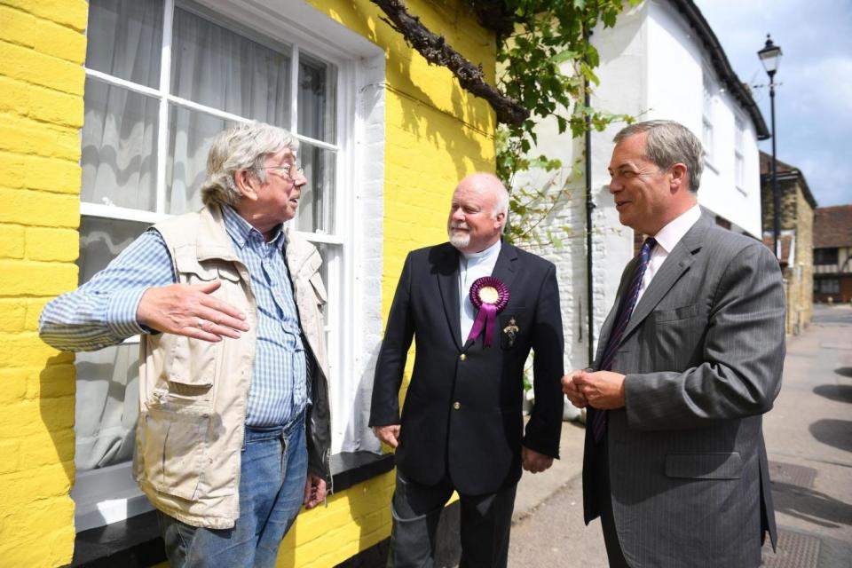 Nigel Farage and Ukip candidate Rev. Stuart Piper speak to a voter (PA)