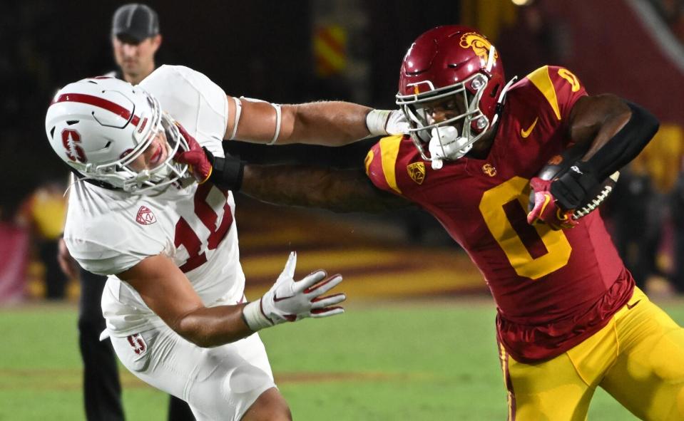 USC running back MarShawn Lloyd stiff arms Sanford linebacker Spencer Jorgensen as he carries the ball.