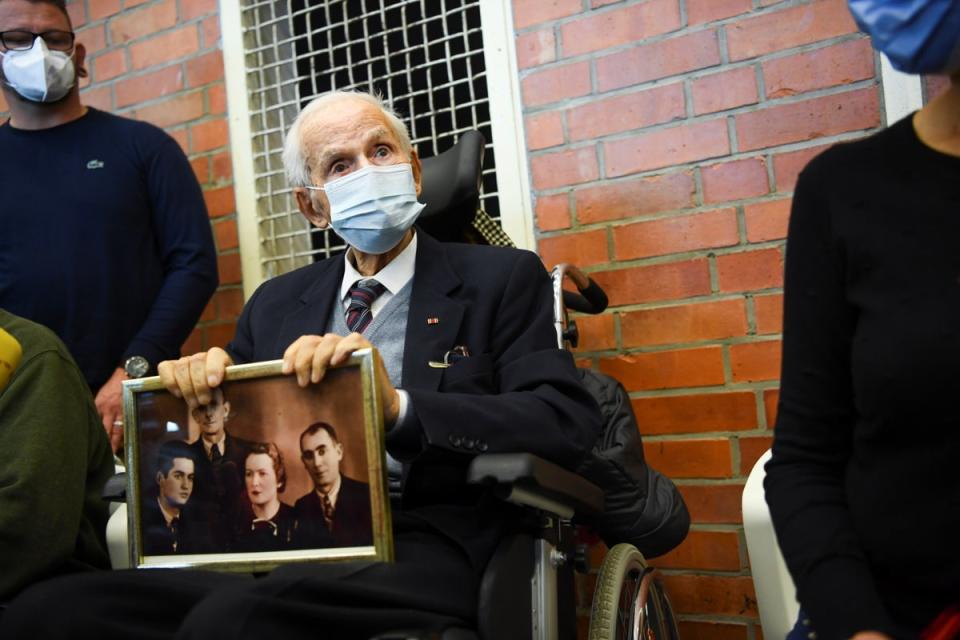 Holocaust survivor Leon Schwarzbaum holds a picture in the courtroom during the trial (Reuters)