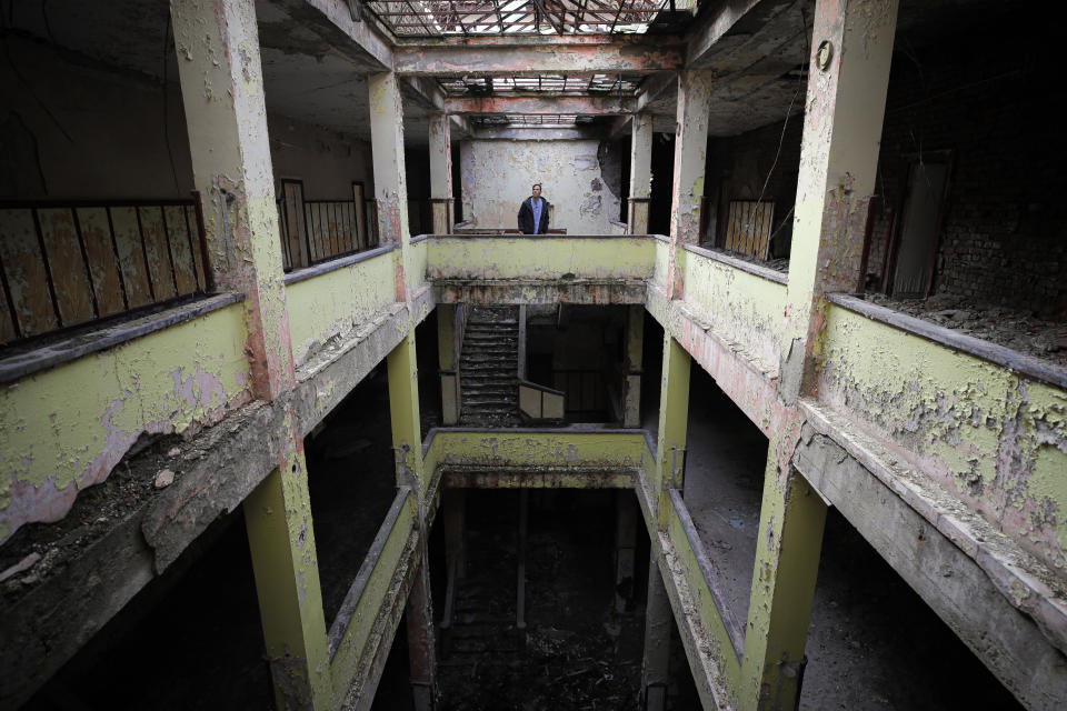In this photo taken on Monday, Dec. 16, 2019, Florin Catanescu, 41, walks through the ruins of the state orphanage that was his home between 1988 and 1997 in Busteni, Romania. Thirty years after the 1989 death of Romania's communist-era dictator, the country is still grappling with the ugly legacy of its once-horrific orphanages. Now some of those who grew up abused and unloved in those failed institutions are turning their trauma into commitment. Florin Catanescu, who lived in an orphanage until 1997, now runs a transition home helping those leaving state care to have a better chance of leading meaningful lives. (AP Photo/Vadim Ghirda)