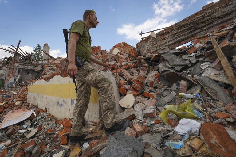 Un soldado ucraniano mira los escombros de una escuela destruida hace unos días durante un ataque con misiles, en las afueras de Kharkiv