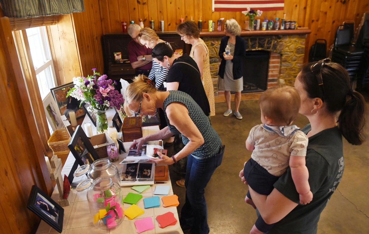 Mourners look at the display of Jessica Hiatt's mementos during her celebration of life service at Nelson Park in Slater on Monday, May 16, 2022.