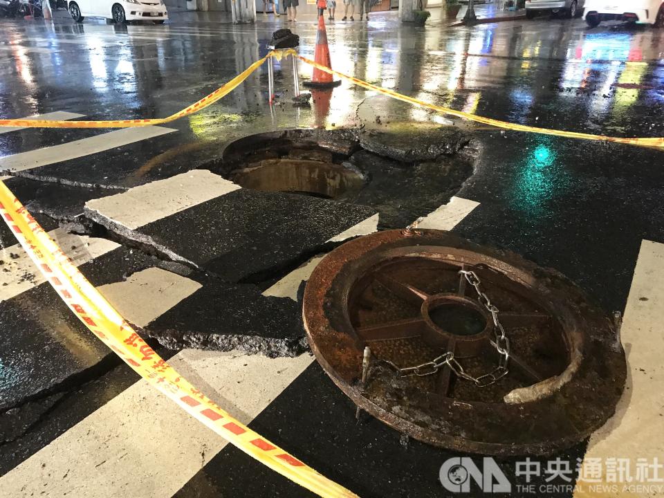 台北市區8日午後暴雨，西門町一帶發生水柱衝破人孔蓋造成路面破損，警方獲報到場拉起封鎖線，避免人車誤闖受傷。(中央社)