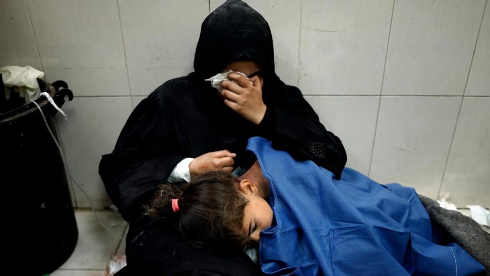 PHOTO: A Palestinian woman cries as she sits next to her girl wounded in the Israeli bombardment of the Gaza Strip while receiving treatment at the Nasser hospital in Khan Younis, Southern Gaza Strip, Jan. 22, 2024.  (Mohammed Dahman/AP)