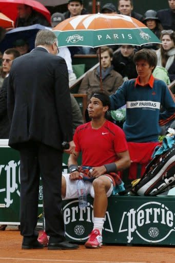 Spain's Rafael Nadal talks with the referee prior to the rain interruption during his French Open men's singles final against Serbia's Novak Djokovic at Roland Garros in Paris on June 10