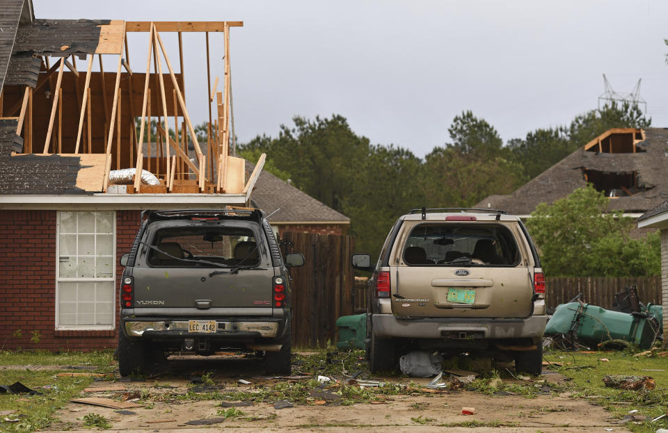 Damaged homes and vehicles are seen along Elvis Presley Drive in Tupelo, Miss., Monday, May 3, 2021. A line of severe storms rolled through the state Sunday afternoon and into the nighttime hours. Late Sunday, a “tornado emergency” was declared for Tupelo and surrounding areas. (AP Photo/Thomas Graning)