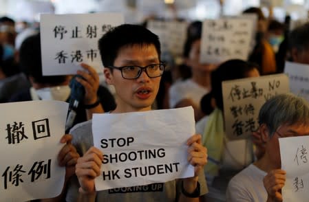 Protesters hold signs following a day of violence over a proposed extradition bill, outside the Legislative Council building in Hong Kong