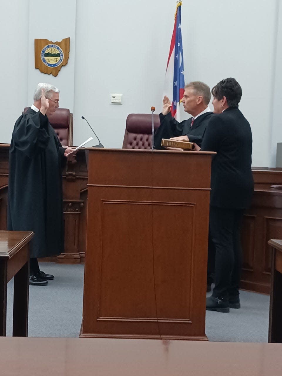 Common Pleas Court Judge Daniel Padden (center) is sworn in to a new six-year term by Judge David Bennet.