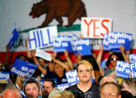 Supporters look on as U.S. Democratic presidential candidate Hillary Clinton delivers a speech during a campaign stop in Fresno, California, United States June 4, 2016. REUTERS/Mike Blake