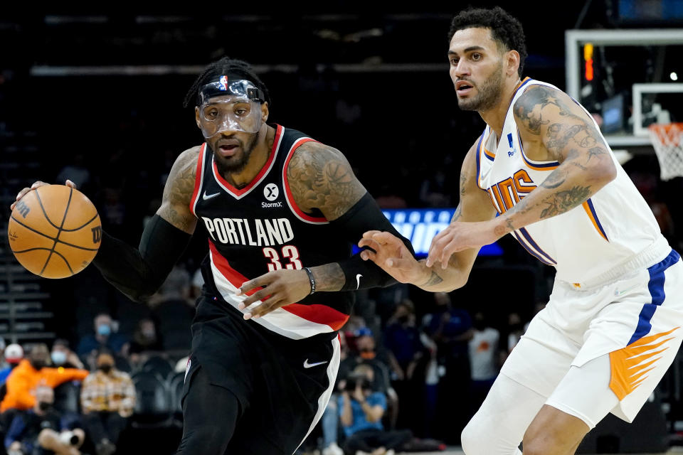 Portland Trail Blazers forward Robert Covington (33) drives as Phoenix Suns forward Abdel Nader defends during the first half of a preseason NBA basketball game, Wednesday, Oct. 13, 2021, in Phoenix. (AP Photo/Matt York)