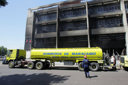 Firefighters are seen at the burned offices of the Housing Ministry in Maracaibo, Venezuela May 25, 2017. REUTERS/Isaac Urrutia