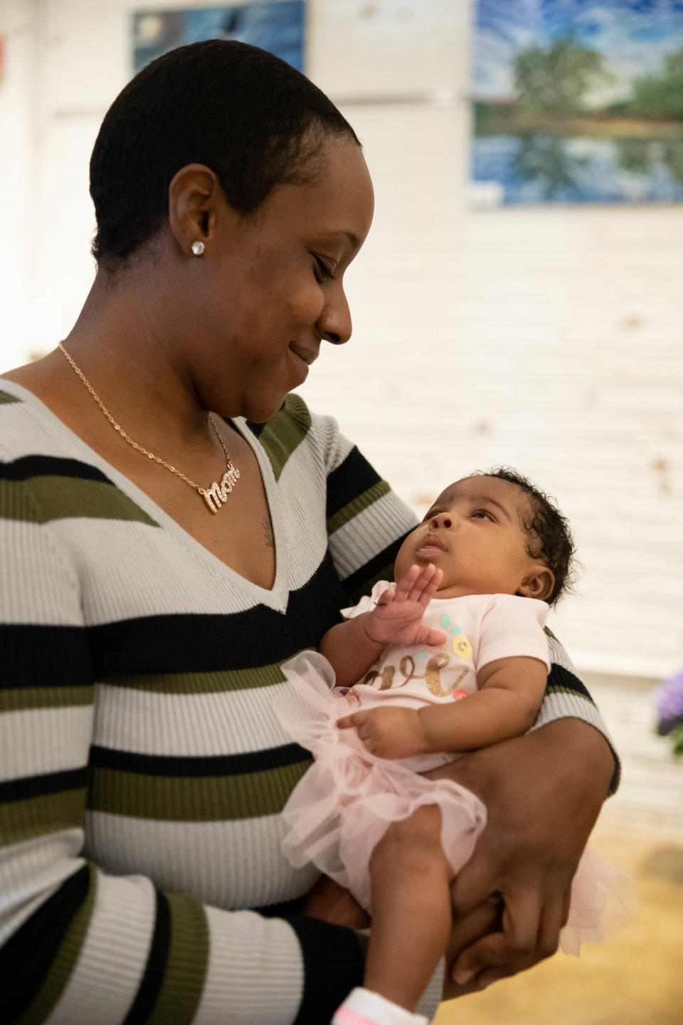Mother of the Year awardee Quiana Frazier holds her two-month-old daughter Honey during the event hosted by Lamb Center for Arts and Healing at Guncotton Coffee in Hopewell, Va. on May 7, 2022.