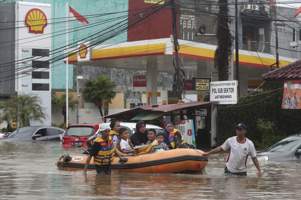 Indonesia rescue team evacuate residents from their flooded house at Jatibening on the outskirt of Jakarta, Indonesia, Wednesday, Jan. 1, 2020. Severe flooding hit Indonesia's capital just after residents celebrating New Year's Eve, forcing a closure of an airport and thousands of inhabitants to flee their flooded homes. (AP Photo/Achmad Ibrahim)