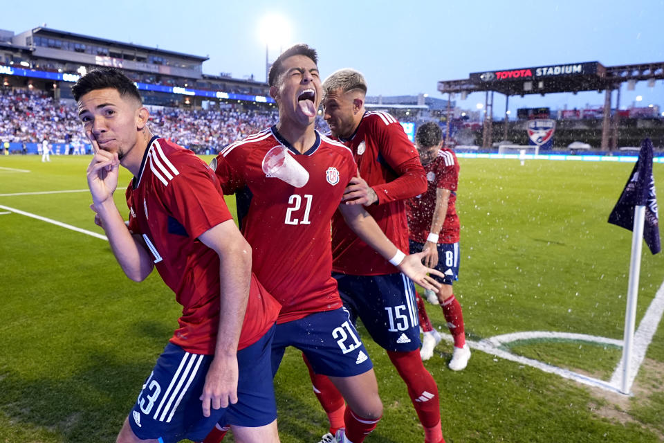 From left, Costa Rica midfielder Jefferson Brenes, Alvaro Zamora (21), Francisco Calvo (15) and Joseph Mora (8) are pelted with drinks and trash after celebrating a Brenes goal in the second half of a CONCACAF Nations League Play-In soccer match against Honduras, Saturday, March 23, 2024, in Frisco, Texas. (AP Photo/Julio Cortez)