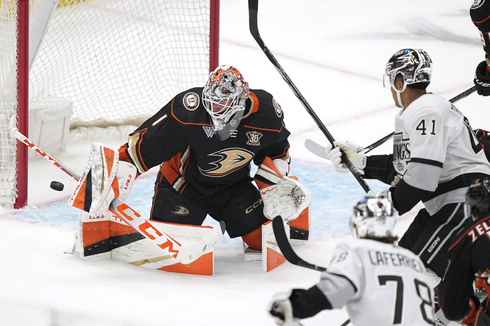 Anaheim Ducks goaltender Lukas Dostal, left, deflects a shot by Los Angeles Kings center Akil Thomas, right, as right wing Alex Laferriere watches during the third period of an NHL hockey game Saturday, April 13, 2024, in Los Angeles. (AP Photo/Mark J. Terrill)