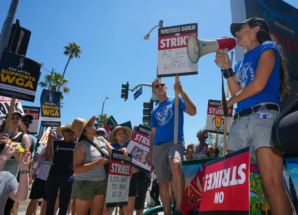 Justine Bateman, right, speaks outside Netflix during a Writers Guild rally as a strike by The Screen Actors Guild-American Federation of Television and Radio Artists is announced on Thursday, July 13, 2023, in Los Angeles. This marks the first time since 1960 that actors and writers will picket film and television productions at the same time.