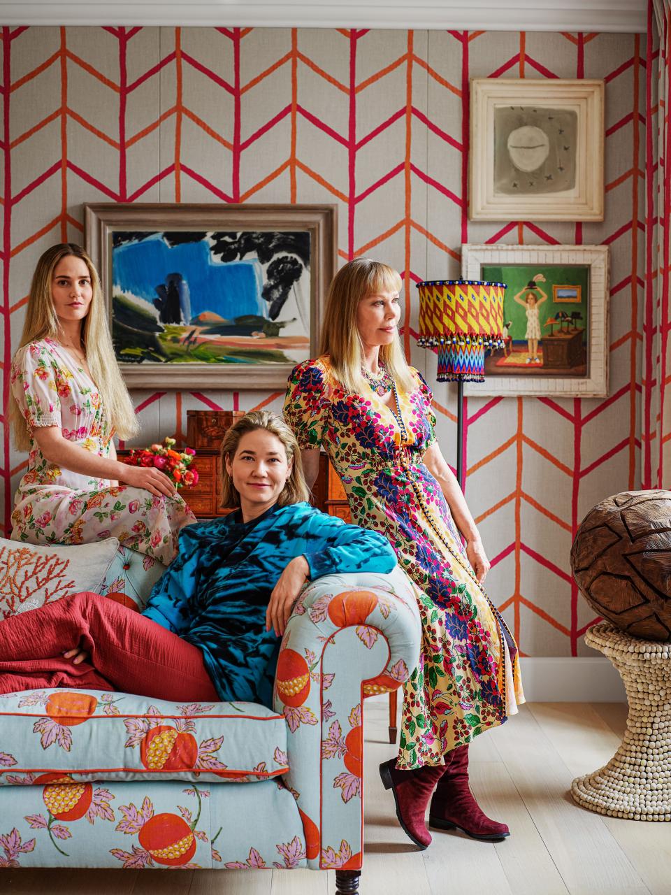 Kemp (right) and her daughters Minnie (center) and Willow lounge on the drawing room sofa, which wears a linen by Raoul Textiles.