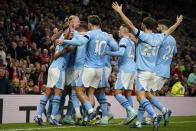 Manchester City's Erling Haaland, left, celebrates after scoring his side's opening goal from a penalty kick during the English Premier League soccer match between Manchester United and Manchester City at Old Trafford stadium in Manchester, England, Sunday, Oct. 29, 2023. (AP Photo/Dave Thompson)
