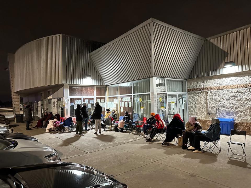 A line up of people outside the BLS international office in Brampton at midnight. Some say they haven't left their spot in the queue since afternoon. 