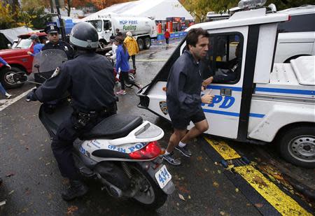 A runner makes his way past New York City Police (NYPD) officers near the finish line of the New York City Marathon in New York's Central Park November 1, 2013. REUTERS/Mike Segar