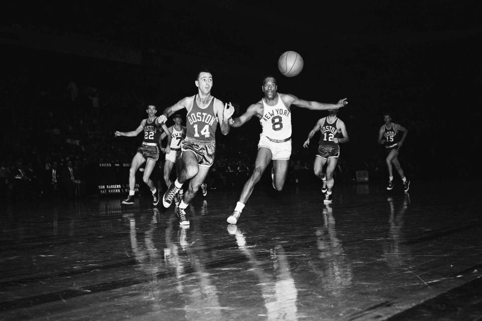 FILE - In this Nov. 12, 1955, file photo, New York's Nat "Sweetwater" Clifton (8) and Boston's Bob Cousy (14) race for a loose ball in an opening period of a basketball game at Madison Square Garden, in New York. Following chase, background, are Boston's Ed Macauley (22) and Togo Palazzi (12), and New York's Gene Shue. (AP Photo/File)