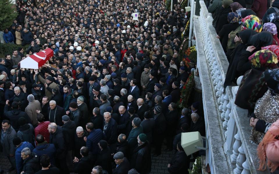 Mourners watch as others carry the Turkish flag-draped coffin of Yunus Gormek, 23, one of the victims of the attack at a nightclub on New Year's Day, during the funeral in Istanbul, Monday, Jan. 2, 2017. Turkey's state-run news agency says police have detained eight people in connection with the Istanbul nightclub attack. The gunman, who escaped after carrying out the attack, wasn't among the eight. The Islamic State group has claimed responsibility for the attack, which killed 39 people, most of them foreigners. (AP Photo/Emrah Gurel)