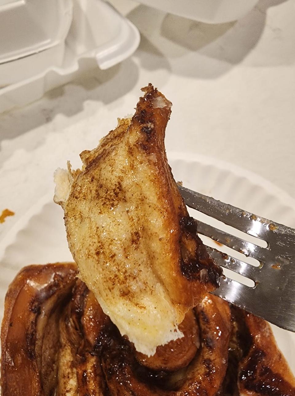 A piece of a cinnamon roll on a fork