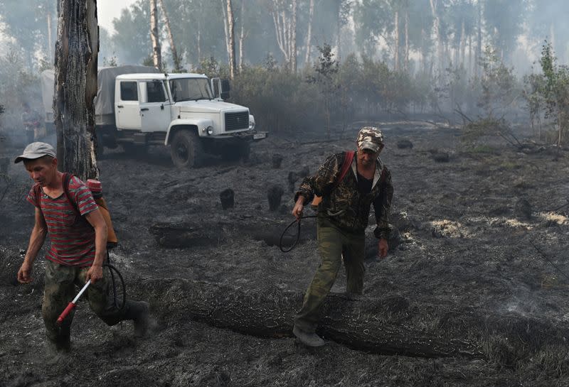 FILE PHOTO: Specialists put out a forest fire in Omsk Region