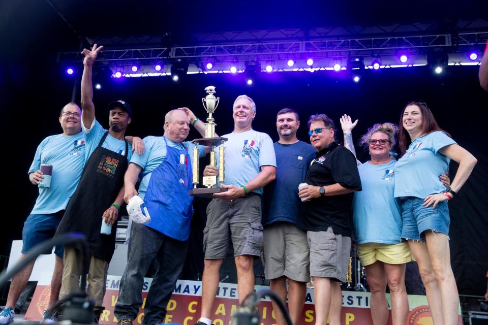 Team members from All-Star Ten Pin Porkers celebrate receiving second place in the “Best Booth” contest during the World Championship Barbecue Cooking Contest as part of the Memphis in May International Festival in Memphis, Tenn., on Thursday, May 16, 2024.