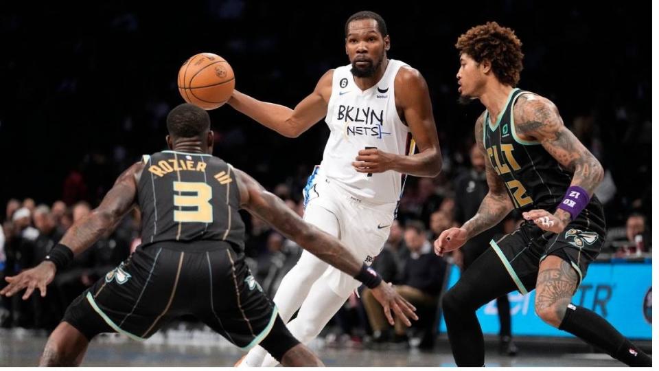 Brooklyn Nets forward Kevin Durant (7) drives against Charlotte Hornets guard Terry Rozier (3) and guard Kelly Oubre Jr. (12) during the second half of an NBA basketball game on Dec. 7, 2022, in New York.