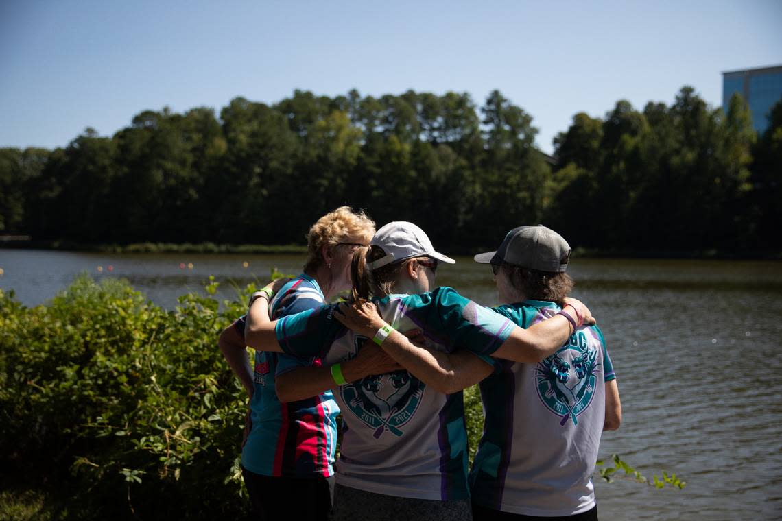The Kazes, made up of survivors of cancer or other illnesses and their caregivers, gather at the edge of the water to watch the Relentless, a team with the Raleigh Dragon Boat Club, compete during the last race of the day at Asia Fest on Sept. 17, 2022, at Booth Amphitheatre in Cary, N.C.