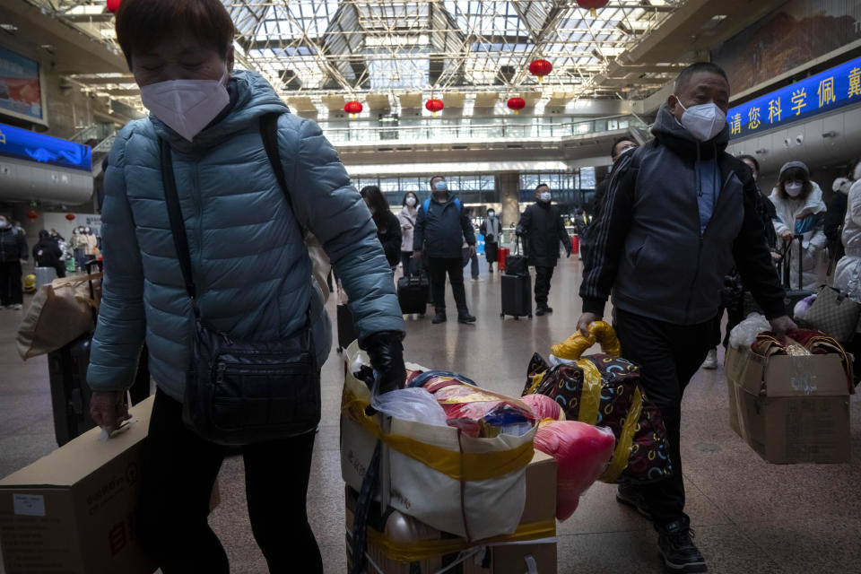 Travelers walk along a concourse at Beijing West Railway Station in Beijing, Wednesday, Jan. 18, 2023. China in December lifted its strict "zero-COVID" policy, letting loose a wave of pent-up travel desire, particularly around China's most important time for family gatherings, referred to in China as the Spring Festival, that may be the only time in the year when urban workers return to their hometowns. (AP Photo/Mark Schiefelbein)