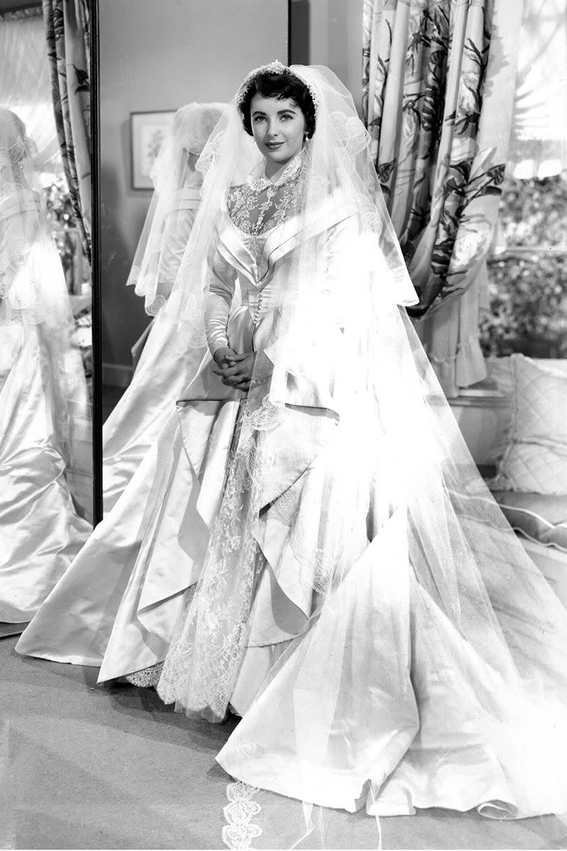<p>Elizabeth Taylor was a vision in satin and lace for Kay Banks's wedding in <em>Father of the Bride</em>. The actress, who's first wedding to Conrad Hilton coordinated with the release of the film, wore a Helen Rose design for both the film <em>and </em>her real-life nuptials.</p>