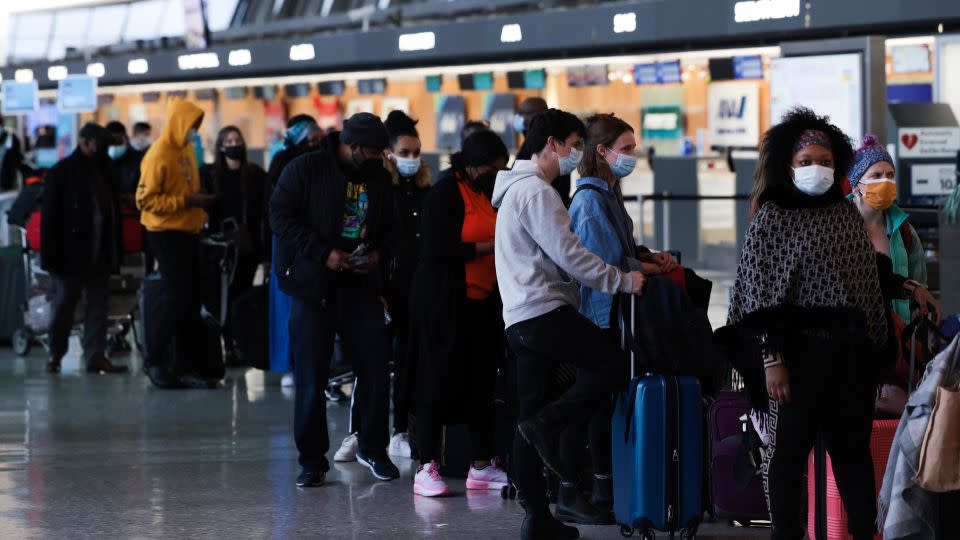 Passengers wait in line to check in for their flights at the Dulles International Airport in Dulles, Virginia, on December 27, 2021.  - Anna Moneymaker/Getty Images