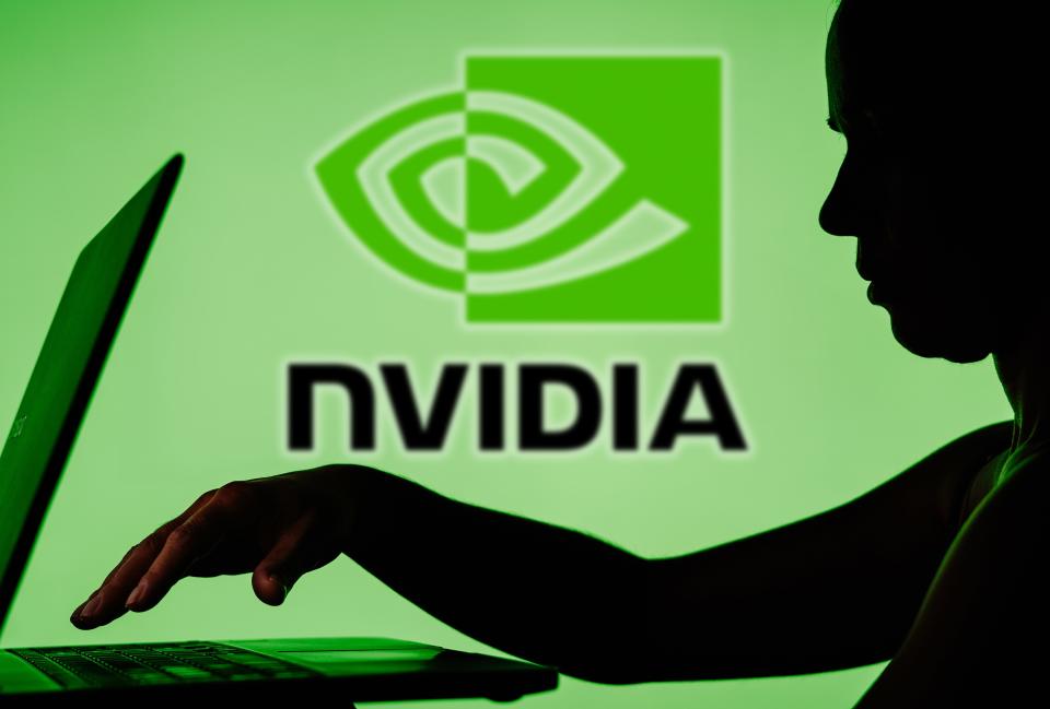 Nvidia logo with a shadow of a person on a laptop in front of it
