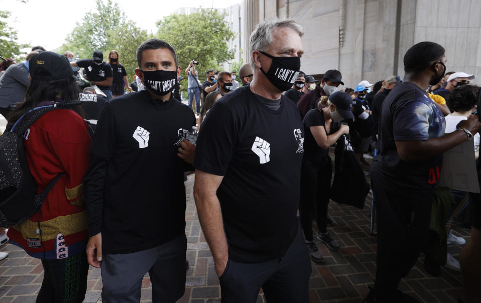 Denver Broncos president and chief executive officer Joe Ellis, right, joins Patrick Smyth, the team's chief communications officer, in taking part in a rally in the Greek Amphitheatre in Civic Center Park over the death of George Floyd Saturday, June 6, 2020, in downtown Denver. (AP Photo/David Zalubowski)