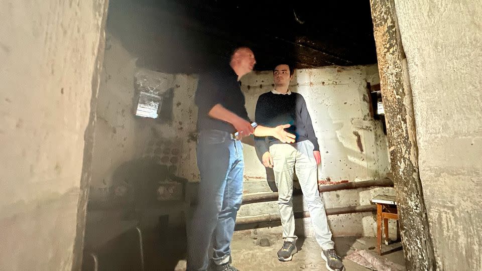 Guide Svitozar Moiseiv and tourist Jean-Baptiste Laborde inside a building that was part of a Soviet army defense fortification during World War II and later became a shelter where a family from the Kyiv suburbs hid from Russian shelling. - Svitlana Vlasova/CNN