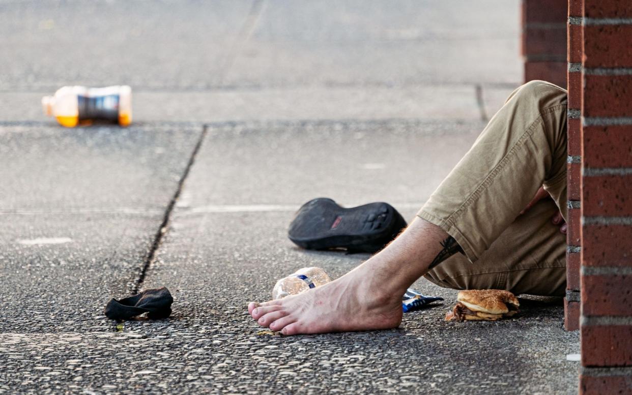 The foot and leg of someone passed out on the pavement in Eugene, Oregon