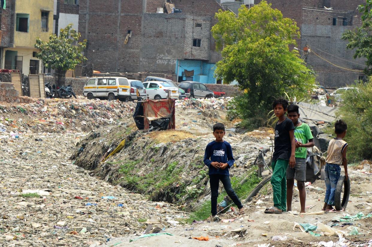 Nitesh Kumar (second from left) and friends play beside a canal covered in plastic waste near their homes in Geeta Colony, New Delhi.&nbsp;India has announced all single-use plastics will be banned by 2022. (Photo: Athar Parvaiz)