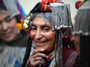 In this July 23, 2011 photo, an Aryan Brogpa woman in traditional outfit smiles at Darchik, in Kargil district of Jammu and Kashmir state, India. The Brogpas, or Dards or Drokpas as they are also known, claim to be pure-blooded Aryans and have been subjects of study and debate of historians and researchers. Brogpas, numbering over a 1000, reportedly practice polygamy and polyandry and are prohibited from marrying outside their community to preserve their racial purity. (AP Photo/Channi Anand)