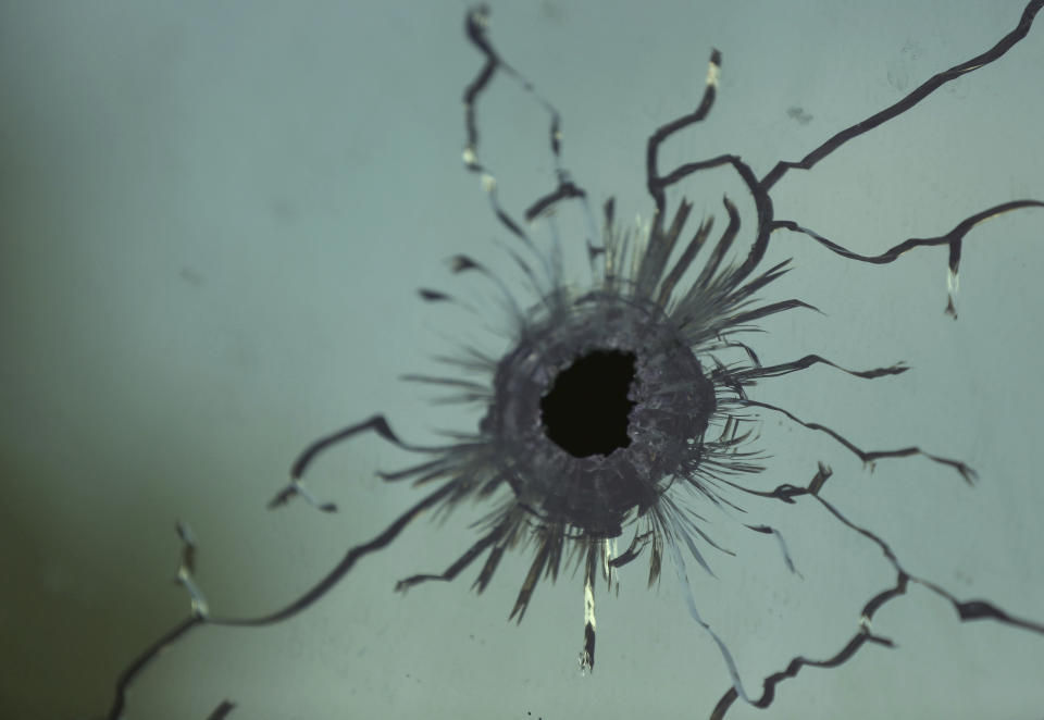 A bullet hole is seen on the glass inside the prison after an attack in the city of Jalalabad, east of Kabul, Afghanistan, Monday, Aug. 3, 2020. An Islamic State group attack on the prison in eastern Afghanistan holding hundreds of its members raged on Monday after killing people in fighting overnight, a local official said. (AP Photo/Rahmat Gul)