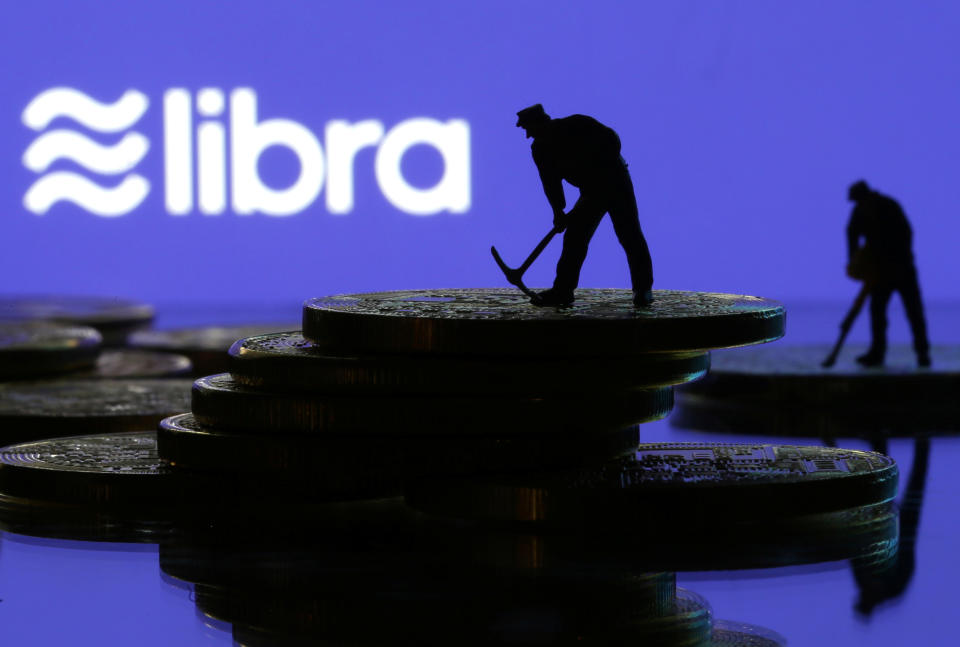 Small toy figures are seen on representations of virtual currency in front of the Libra logo in this illustration picture, June 21, 2019. REUTERS/Dado Ruvic/Illustration