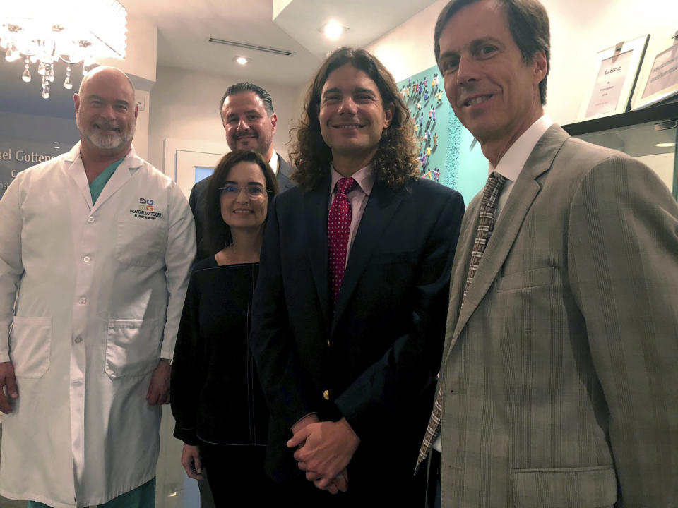 In this Sept. 7, 2018 photo, several members of the Board of Directors of the Venezuelan American Medical Association, VAMA, from left, Doctor Rafael Gottenger, Doctor Marco Bologna, back second left, Doctor Belen Esparis, front second left, Doctor Pedro Morales, second right and Doctor Simon Angeli, right, pose for a photo in Miami, Fla. VAMA is joining a U.S. humanitarian mission to Colombia to assist Venezuelan refugees that flee the crisis in their country. The doctors will be part of a mission aboard the hospital ship USNS COMFORT. (AP Photo/Gisela Salomon)