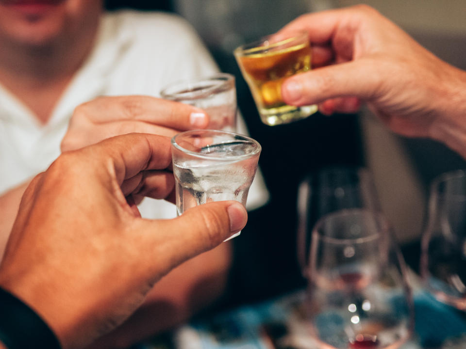 People toasting with shot glasses