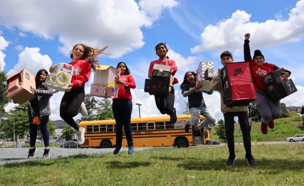 Grade 6 social studies students hold their equity backpacks at Eugene Reimer middle school in Abbotsford.  (Isabelle Raghem/CBC - image credit)